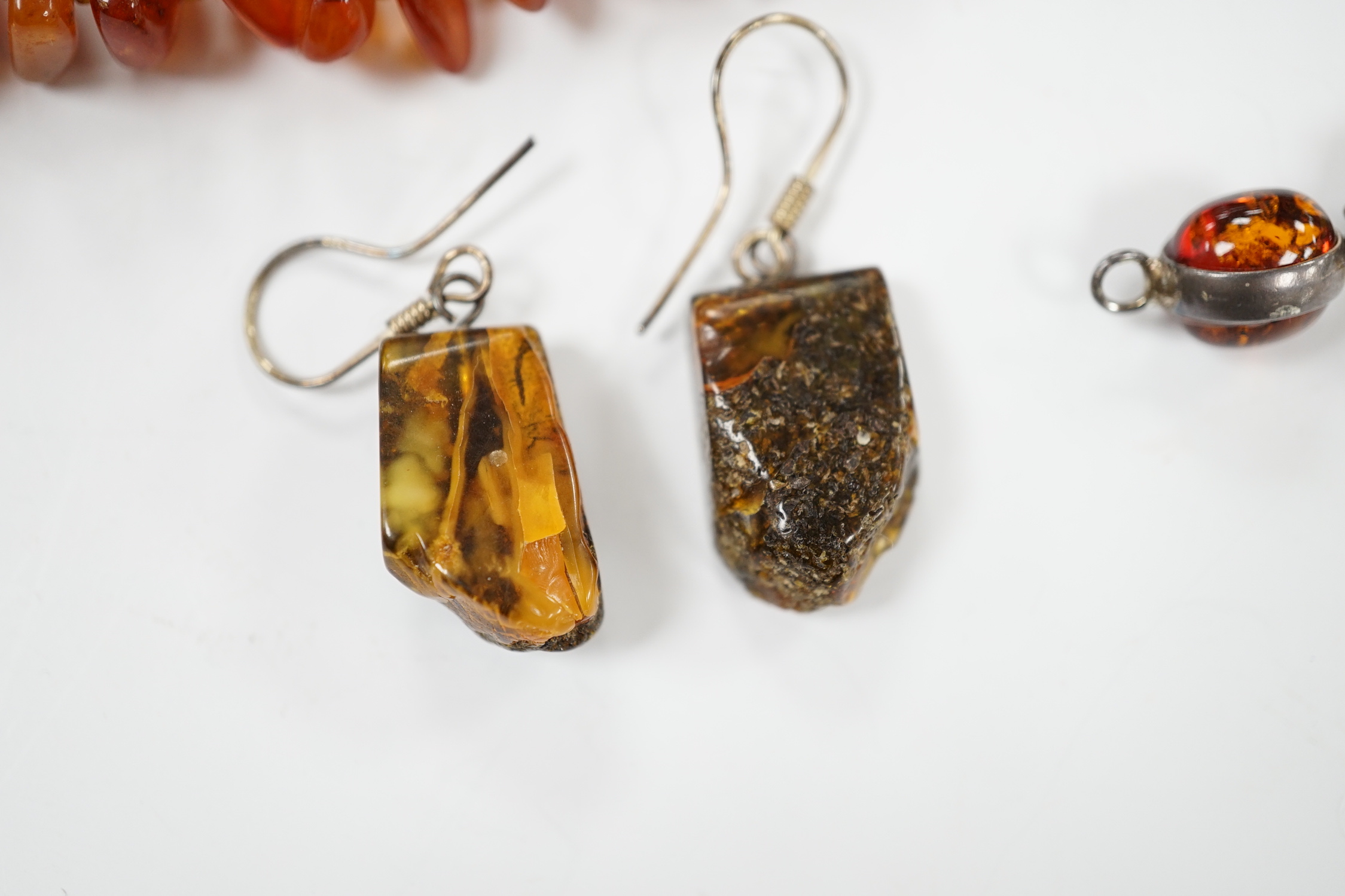 Two white metal and Baltic amber pebble set bracelets, one stamped 925, largest 25cm, a pair of similar drop earrings and an amber necklace.